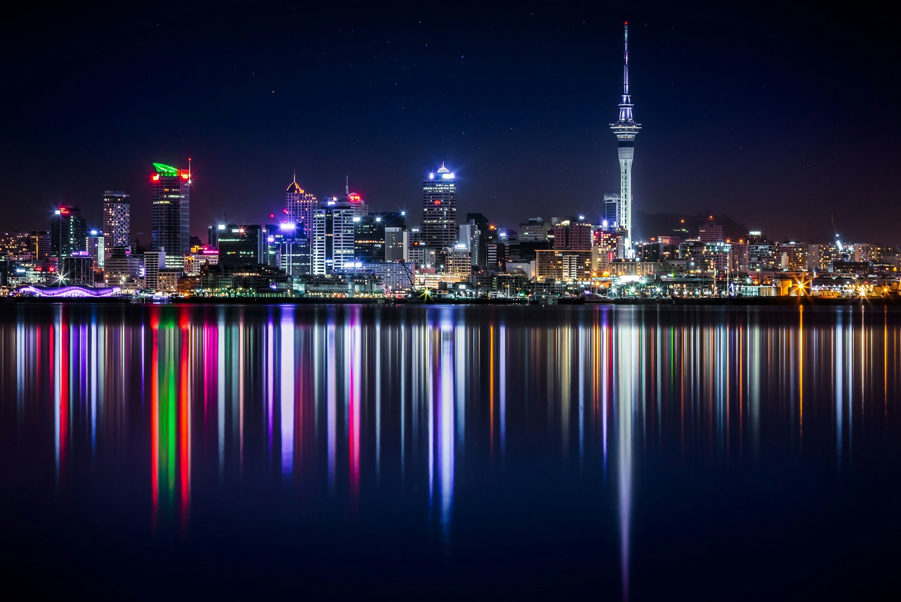 Auckland skyline and Sky Tower reflected across Waitemata Harbour at night