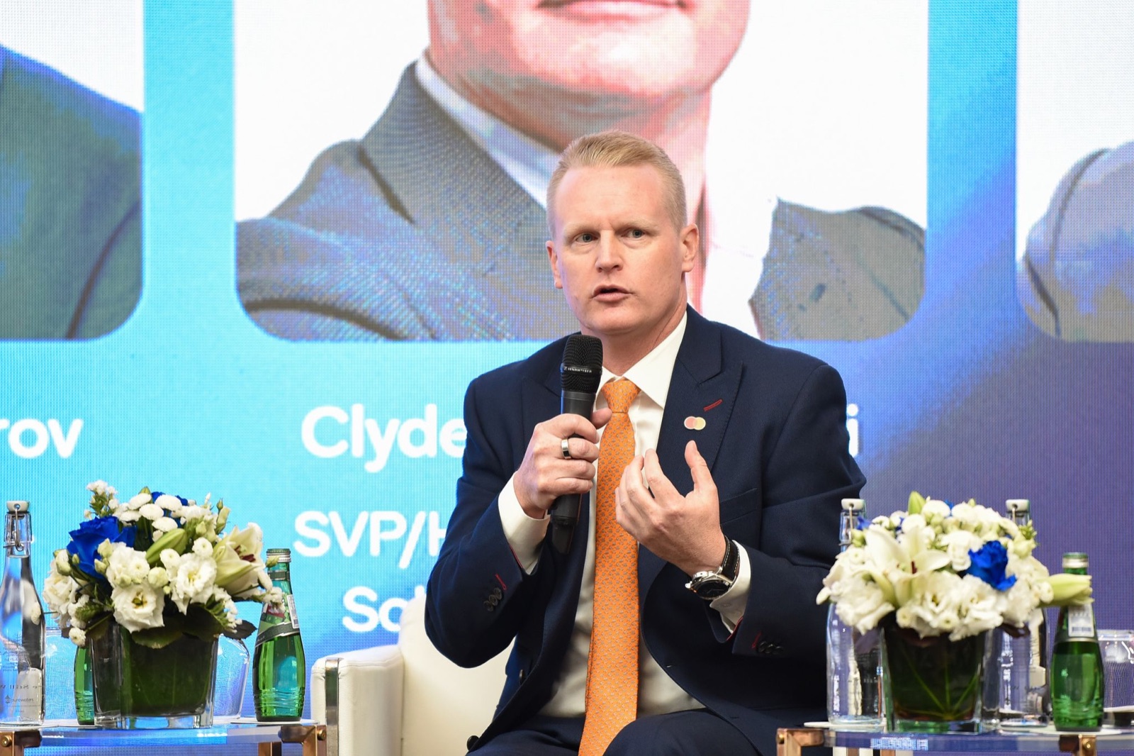 Clyde Rosanowski speaking into a microphone at the QNB Commercial Cards Forum
